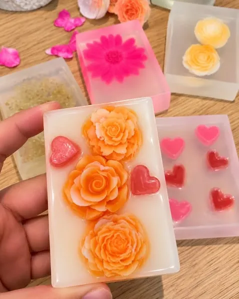 Sabonetes glicerinados artesanais da Fresh Skin com rosas e corações em relevo, segurados na mão